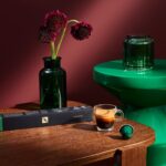 Кофе, зеленая ваза и цветы на столе