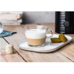 Чашка капучино с пирожными на подносе