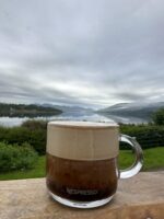 Кофе возле озера с горами на заднем плане