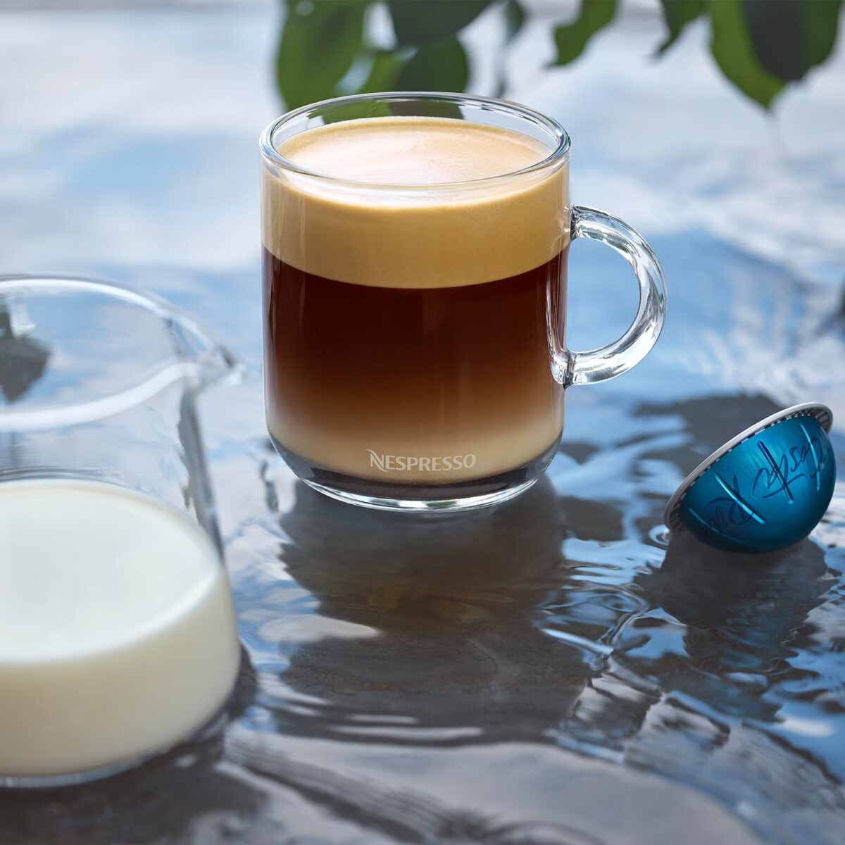 Кружка кофе с молочной пенкой и капсула.