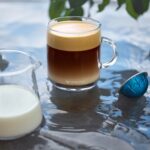 Кружка кофе с молочной пенкой и капсула.