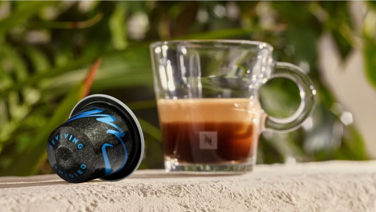 Капсула кофе и чашка эспрессо на столе.