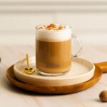 Капучино с корицей в чашке на блюдце