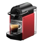 Кофемашина Nespresso красного цвета готовит кофе.