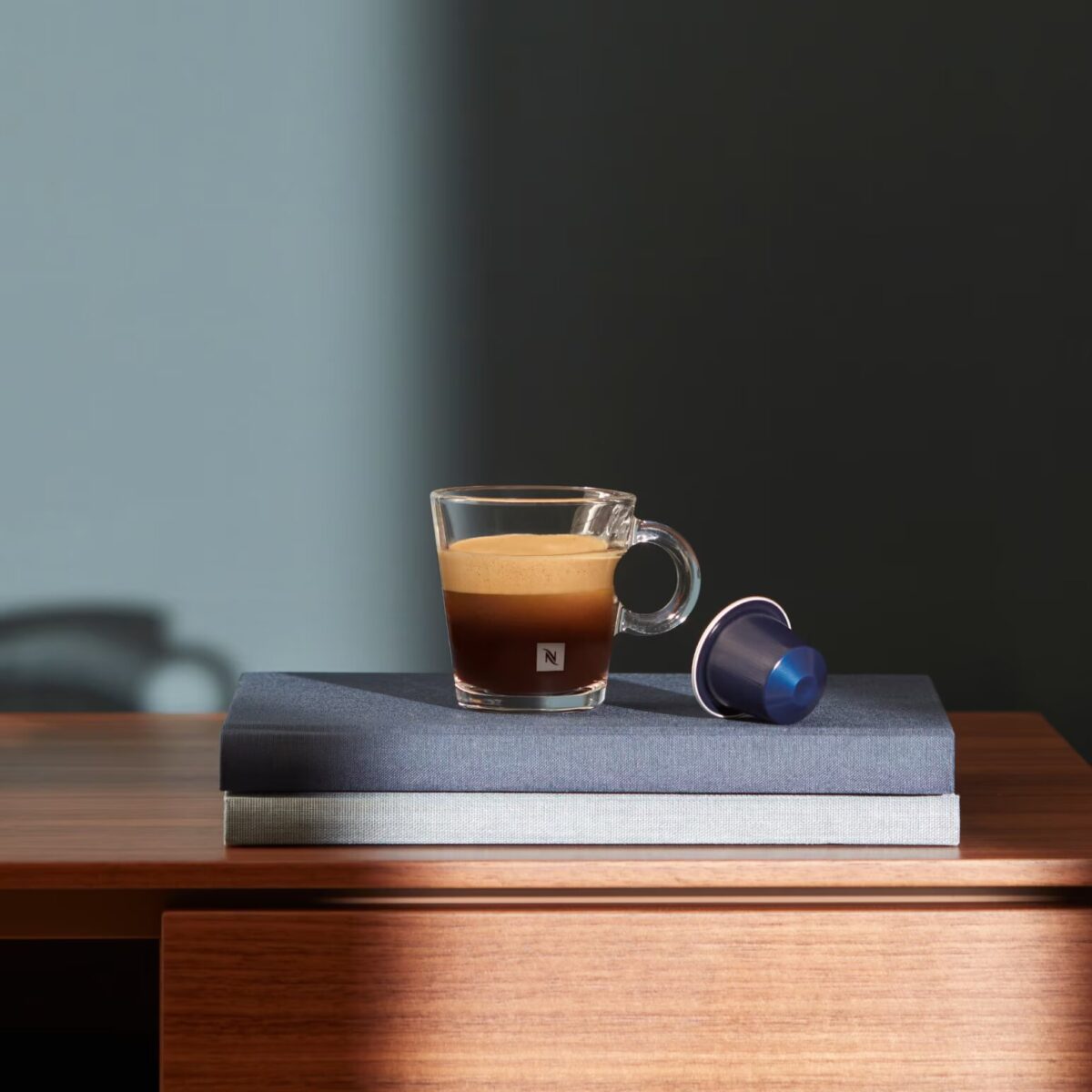 Чашка кофе с капсулой на книге