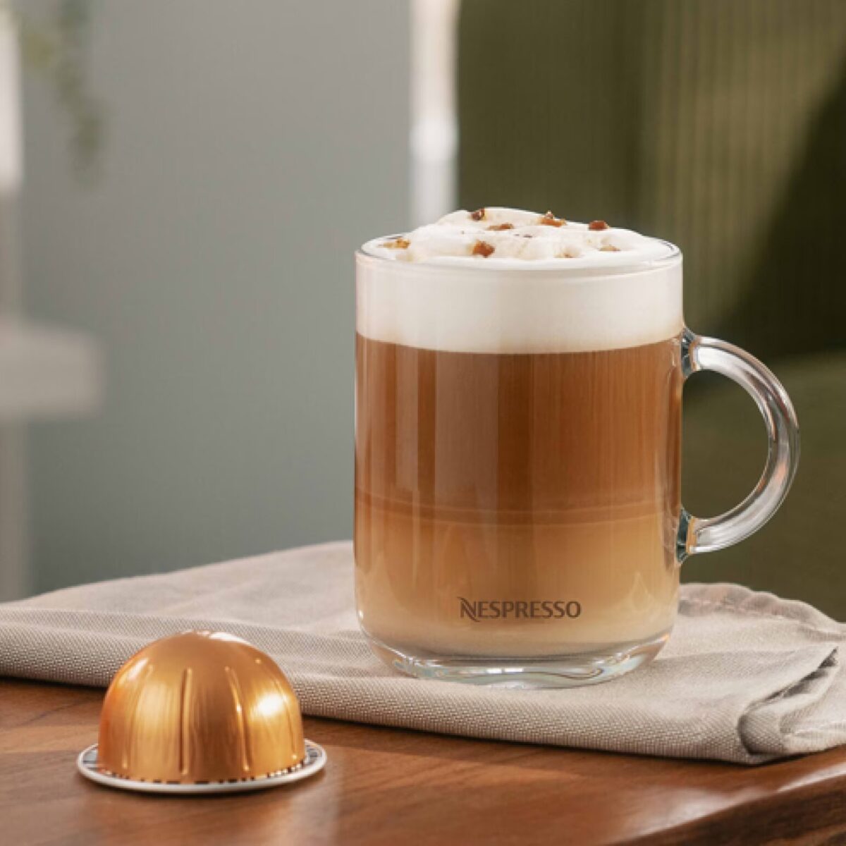 Кофе латте в стеклянной кружке с капсулой.