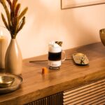 Кофе на деревянном столе с капсулой и декором.