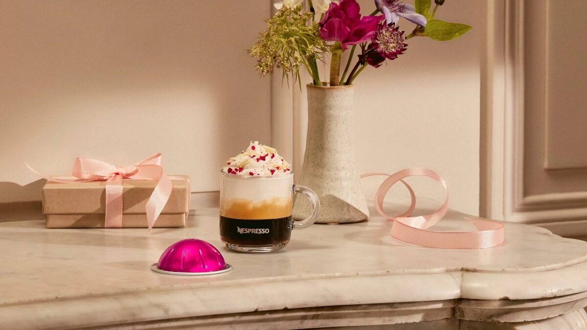 Кофе Nespresso с цветами и подарком на столе.