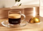 Эспрессо и капсула Nespresso на столе.