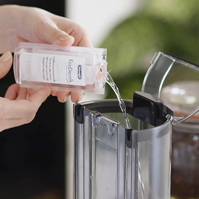 Наливают жидкость в кофемашину.