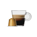 Кружка с эспрессо и золотая капсула кофе