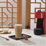 Капучино рядом с кофемашиной и молоком.