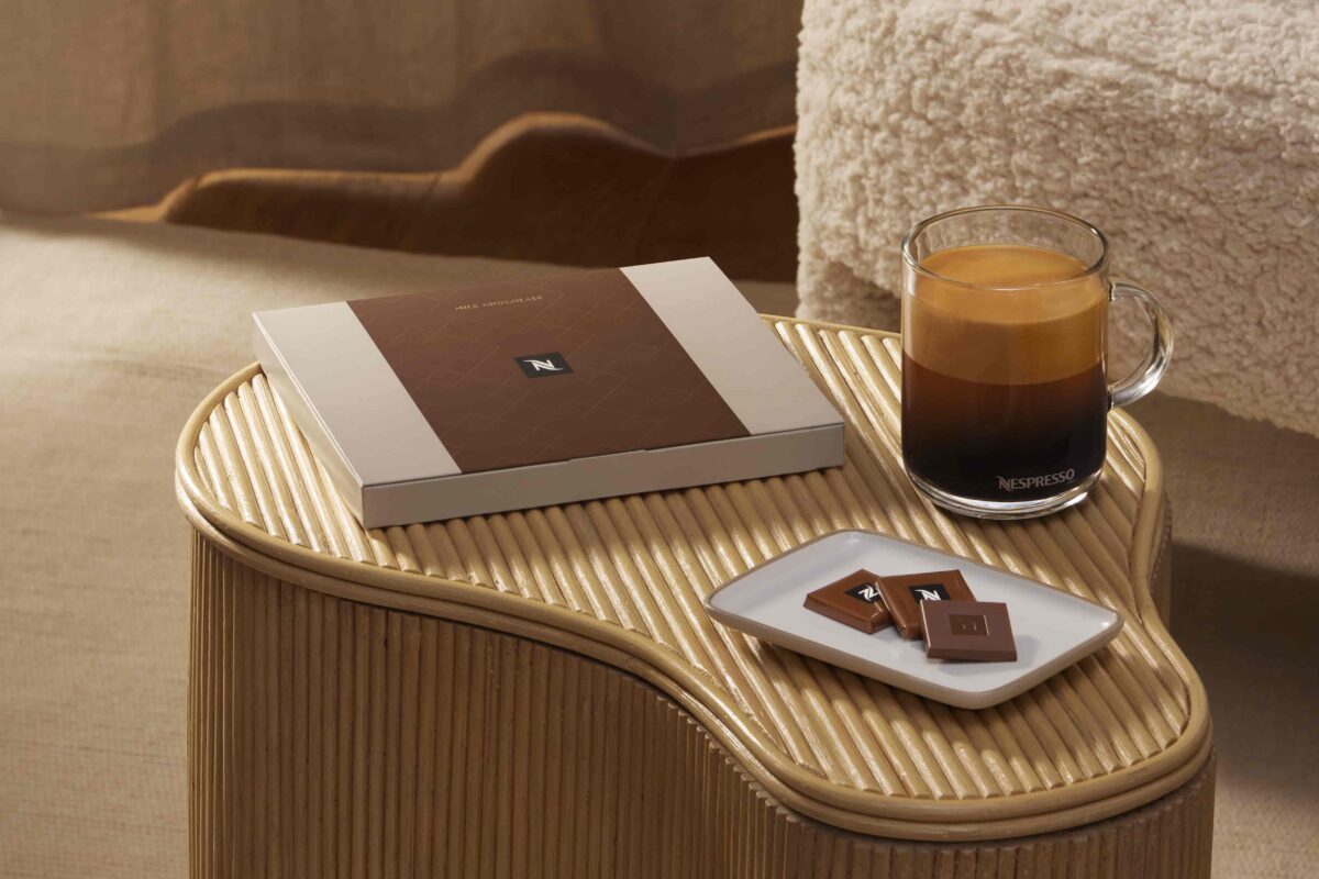 Стакан кофе и шоколад на деревянном столике.